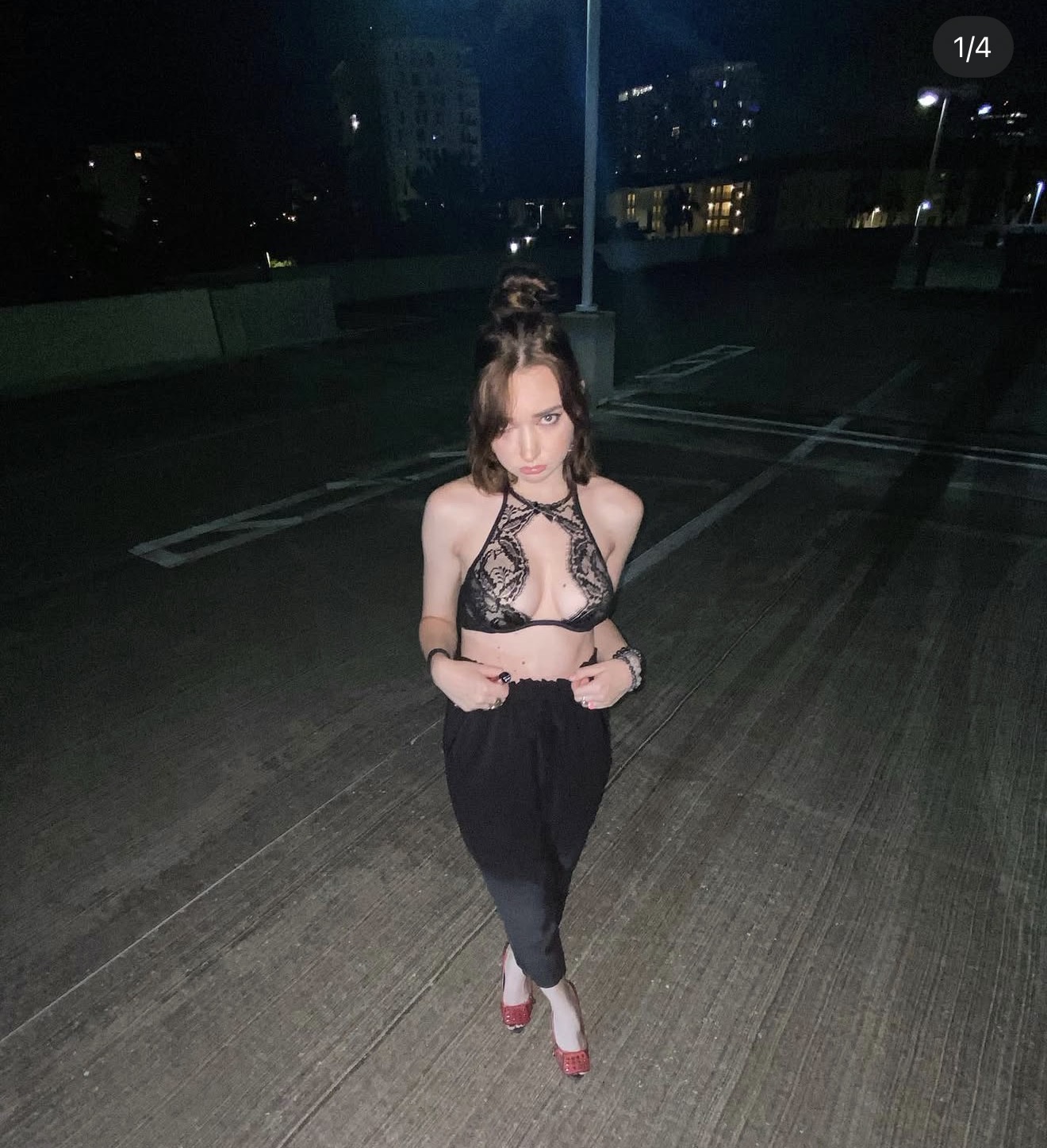 Anastasiya in a black lace halter top on a rooftop at night