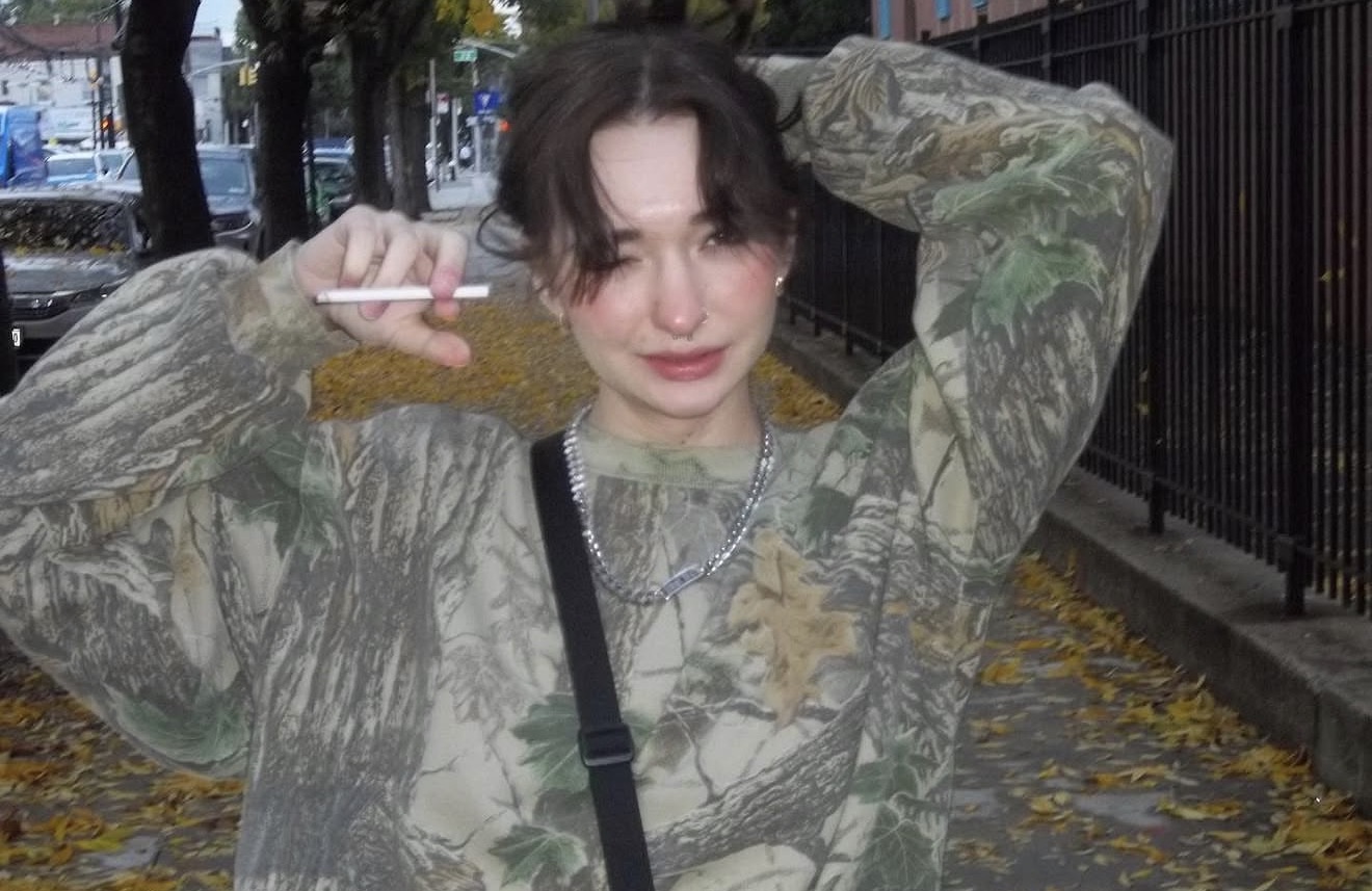 Anastasiya on a quiet fall street in an oversized camo sweatshirt